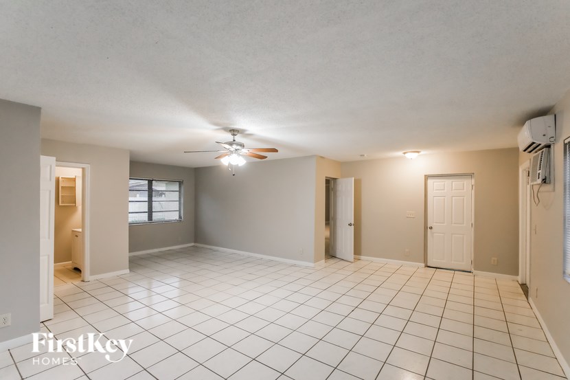 A spacious room with a ceiling fan and tiled flooring.