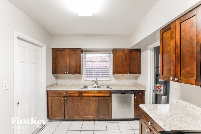 A kitchen with brown cabinets and a white counter top.