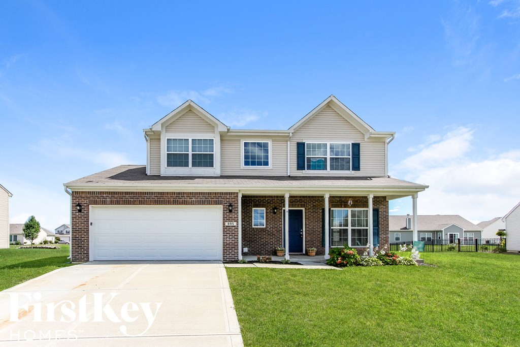 a brick house with a white garage door and a lawn