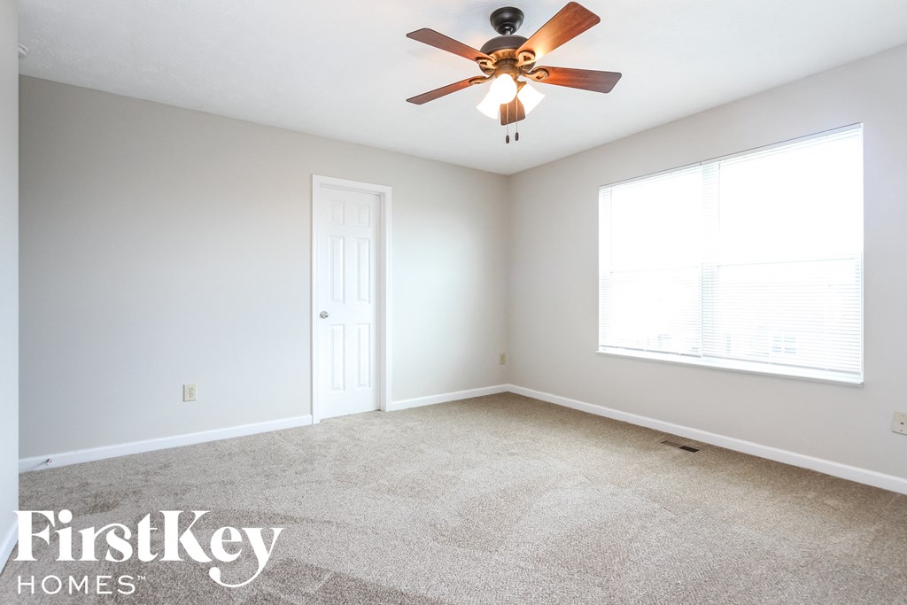 a bedroom with a ceiling fan and a window