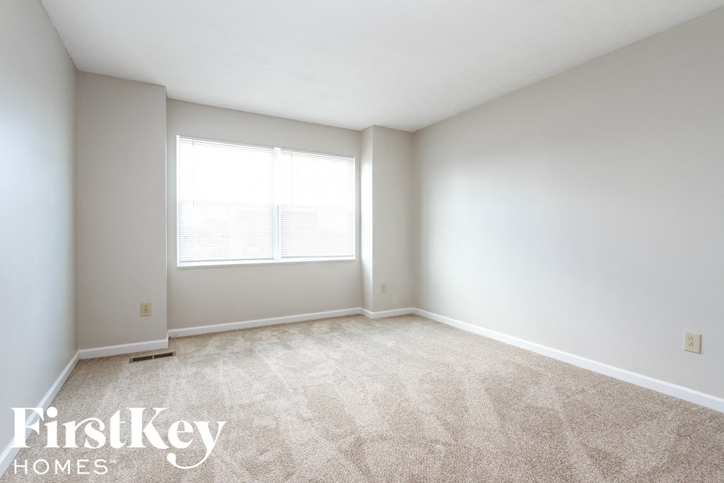 an empty room with carpet and a window