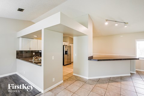 A kitchen area with a counter and a fridge.