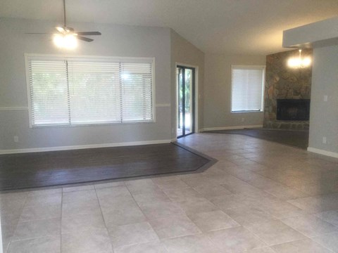 A living room with a fireplace and a rug on the floor.