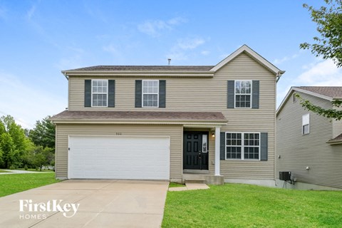 a tan house with a white garage door