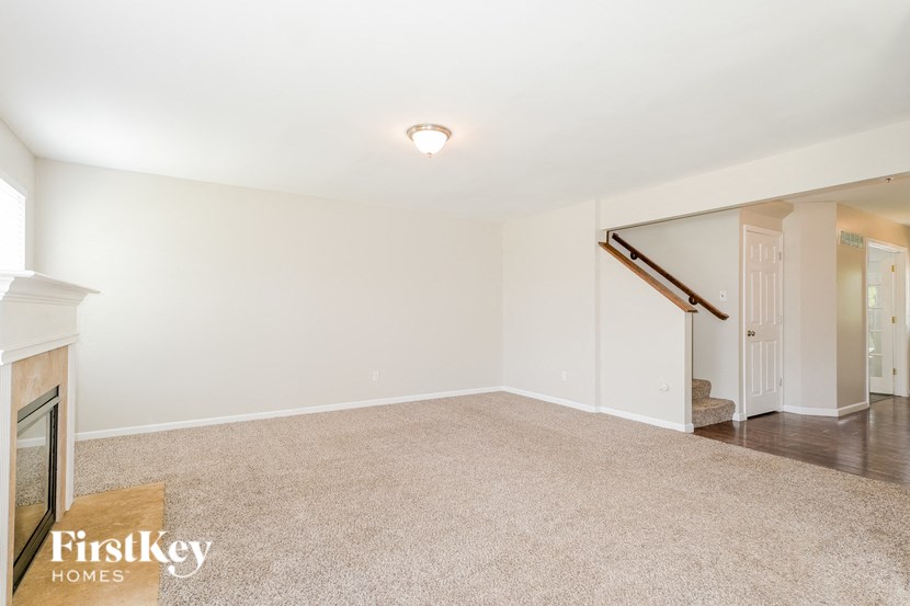 an empty living room with white walls and carpet