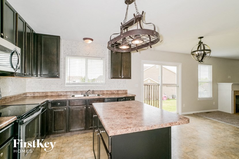 a kitchen with black cabinets and a marble counter top