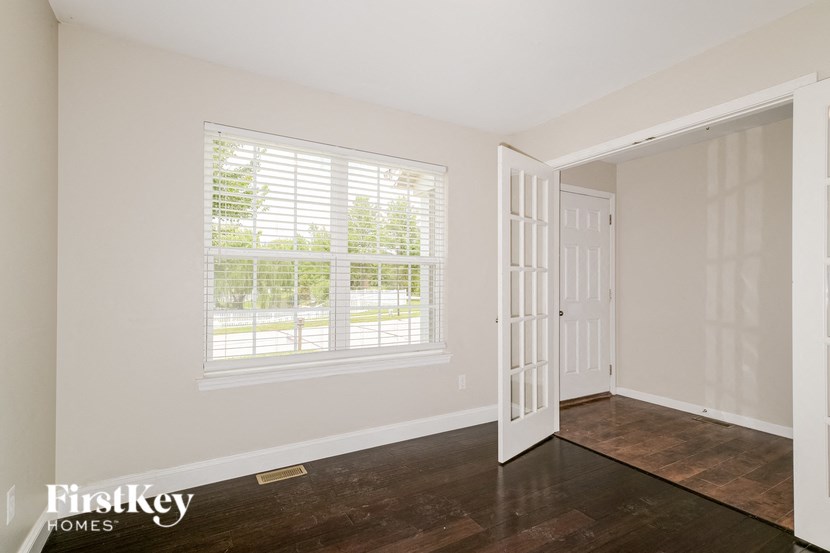 the living room of a home with a large window and a door