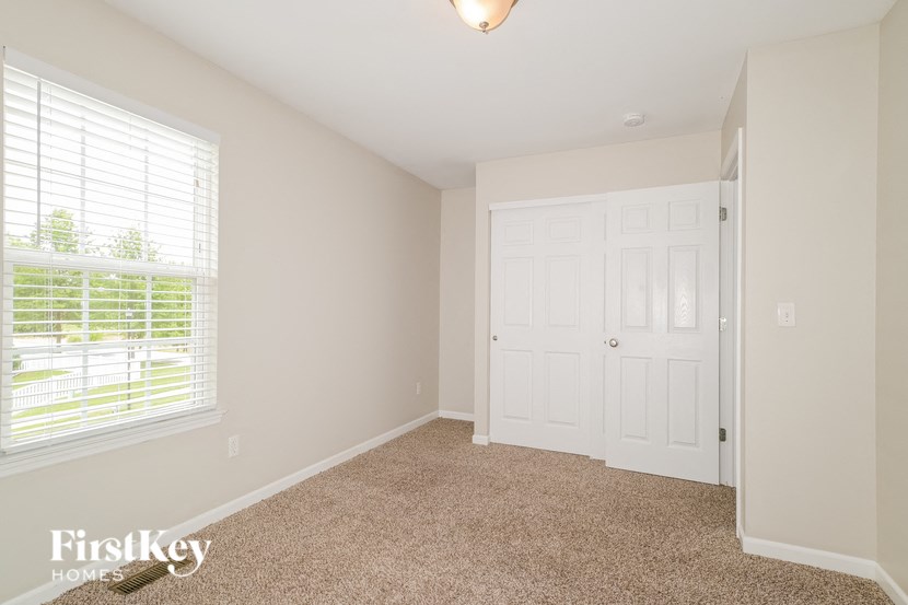 a bedroom with a closet and a window and a door
