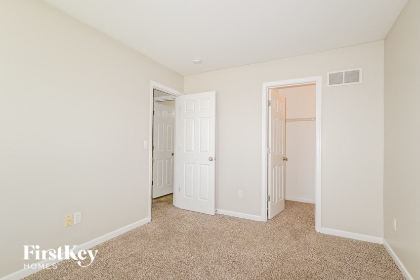 a bedroom with two closets and a door to another room
