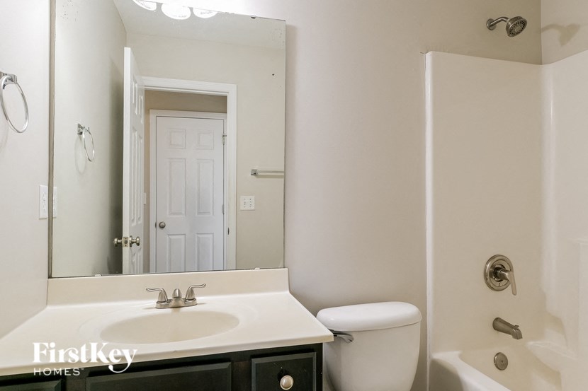 a bathroom with a sink toilet and a mirror