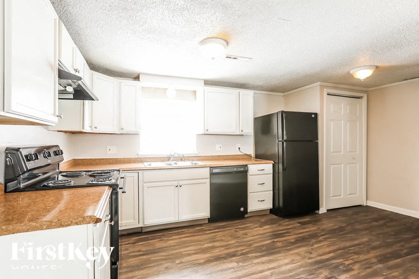 A kitchen with black appliances and white cabinets.