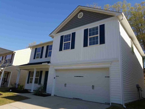 A two-story house with a white garage door.