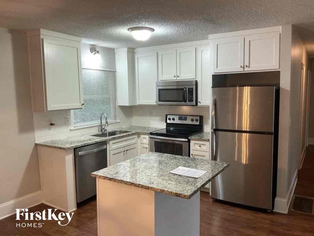 A kitchen with a granite countertop and stainless steel appliances.