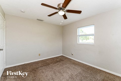 the living room has carpet and a ceiling fan