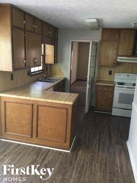 A kitchen with wooden cabinets and a white oven.