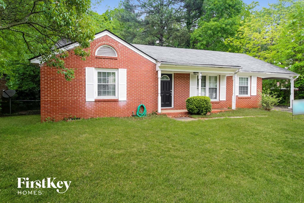 a small brick house with a green lawn and a black door