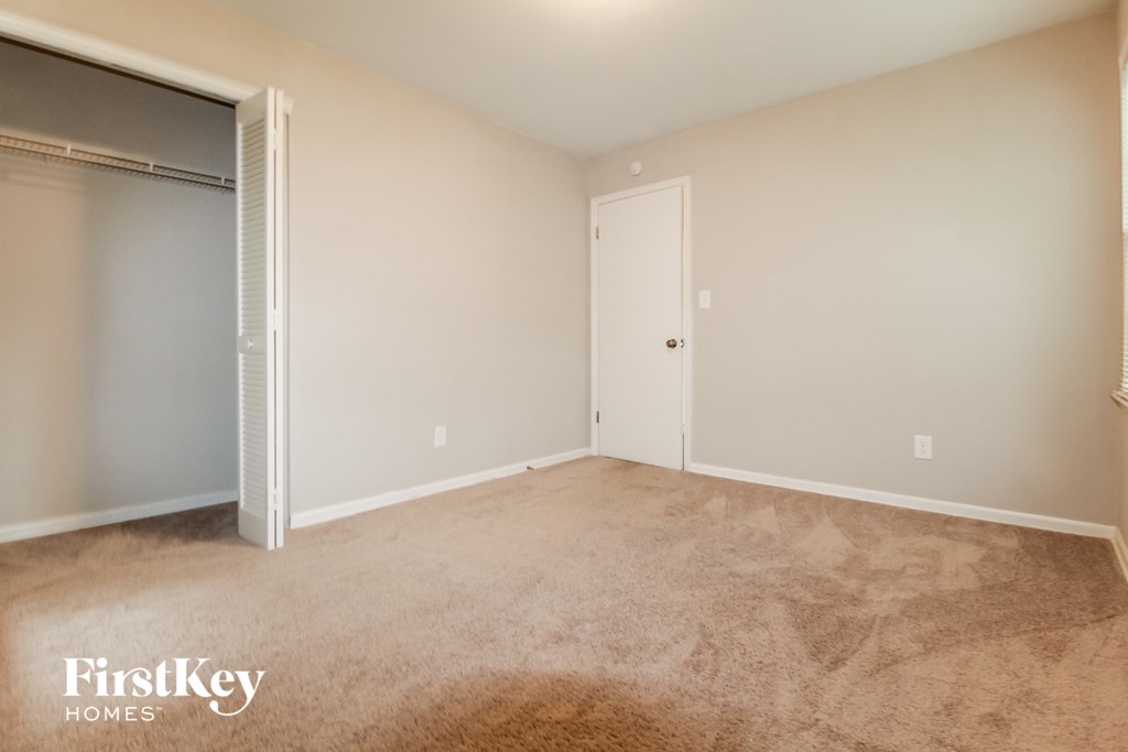 a room with carpet and a door to a closet