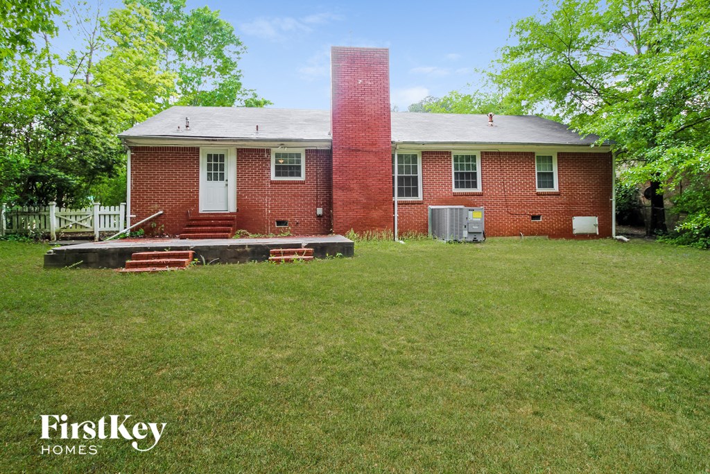 the back of a brick house with a chimney on the front