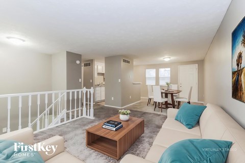A living room with a white couch and a wooden coffee table.