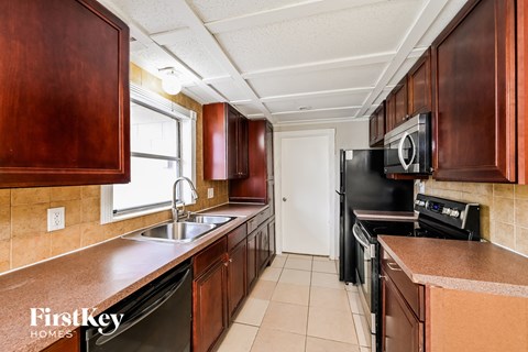 a kitchen with wood cabinets and black appliances and a sink