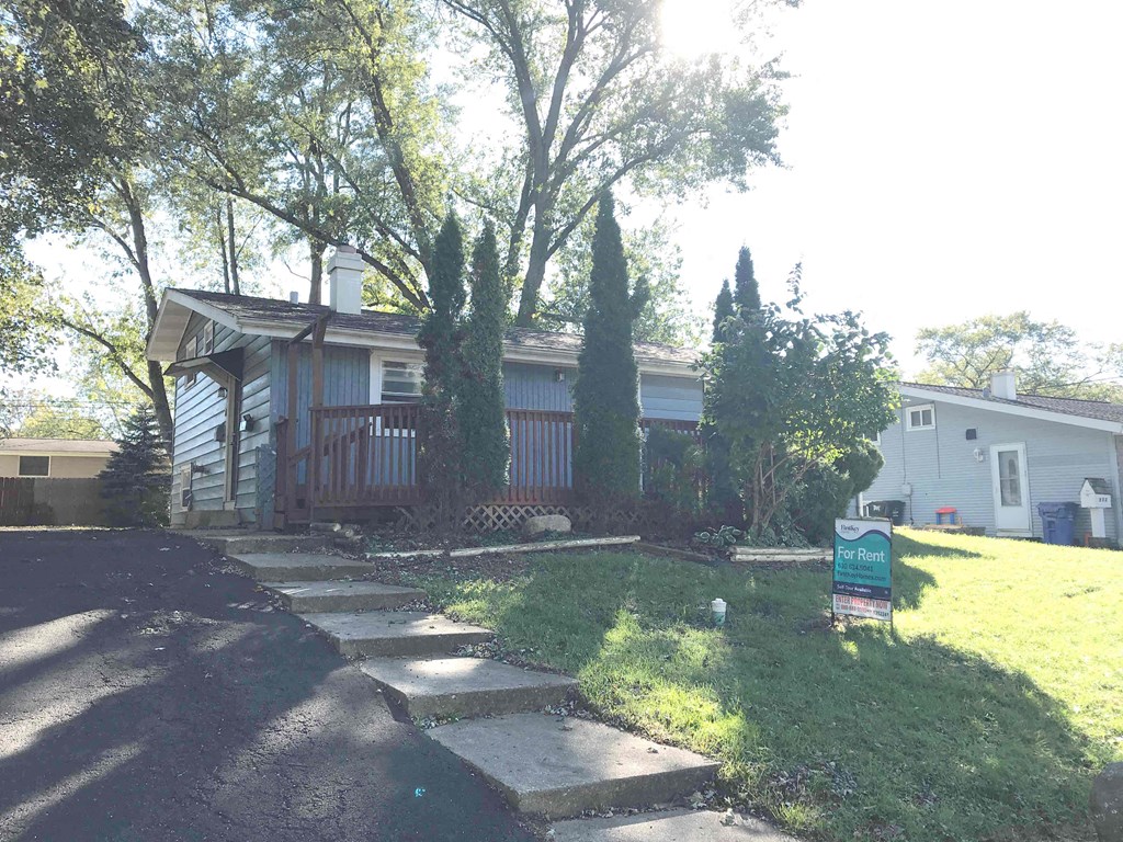 A house with a "For Rent" sign in front of it.