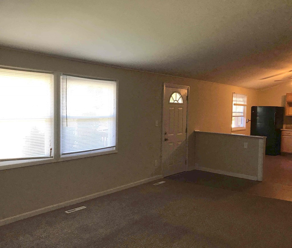 A room with a door, window, and a wall.