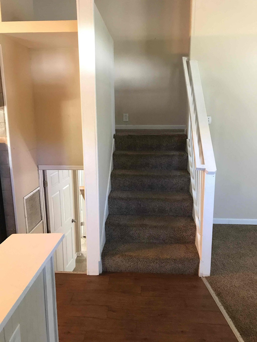 A staircase with a carpeted runner and white railings.