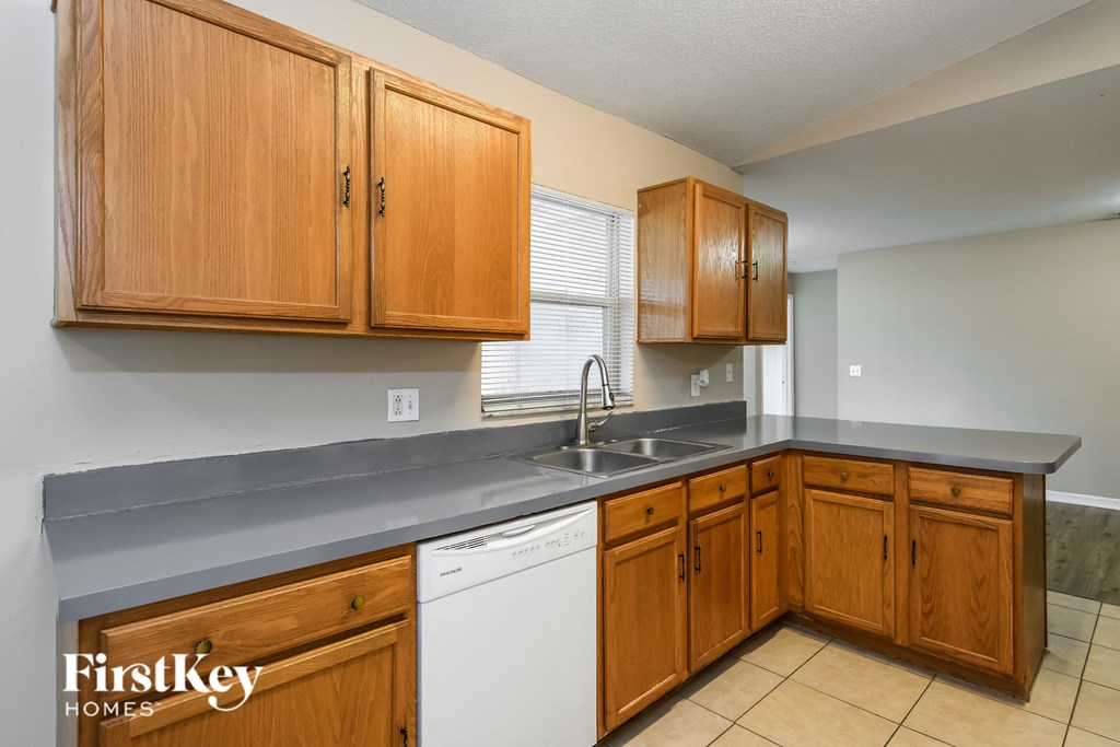 a kitchen with wooden cabinets and a sink and a dishwasher