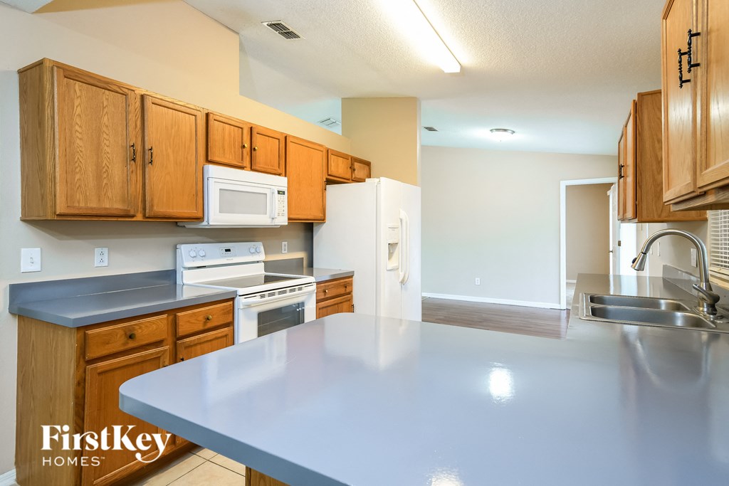 a kitchen with wooden cabinets and white appliances and a counter top