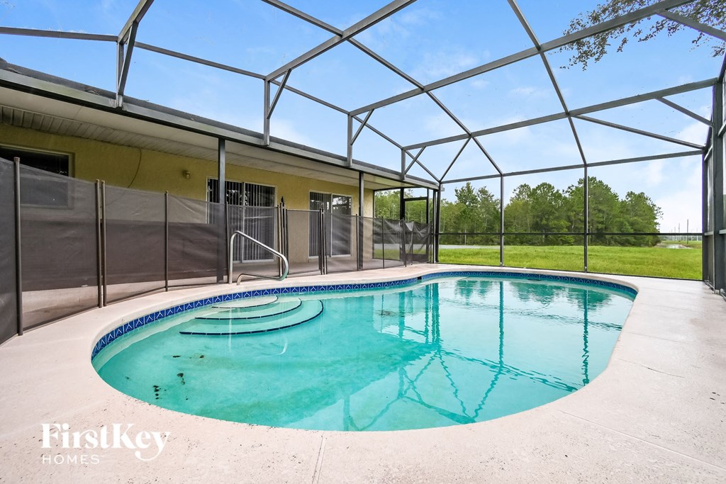 a large pool in a pool house with a fence around it