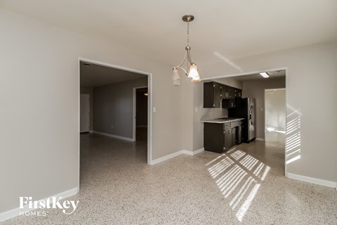 A kitchen area with a refrigerator, sink, and cabinets.