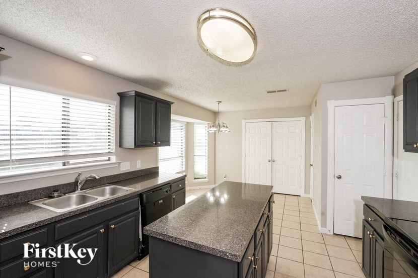 A kitchen with a granite countertop and a FirstKey Homes logo.