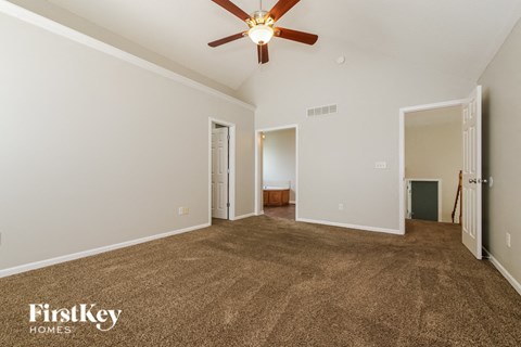 a living room with carpet and a ceiling fan