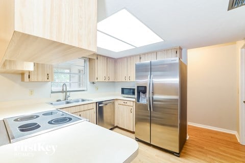 a kitchen with wooden cabinets and a stainless steel refrigerator