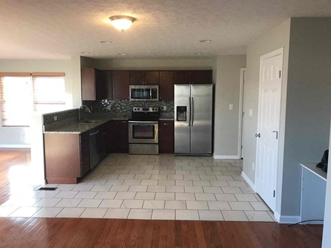 A kitchen with a refrigerator, oven, and microwave.
