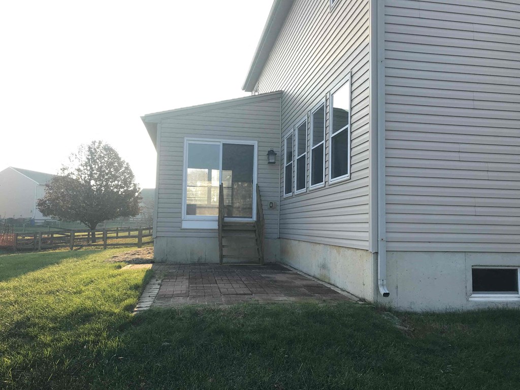 A house with a grey siding and a white door.