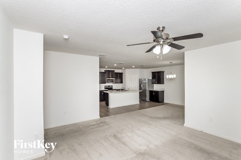 A spacious room with a ceiling fan and light fixture.