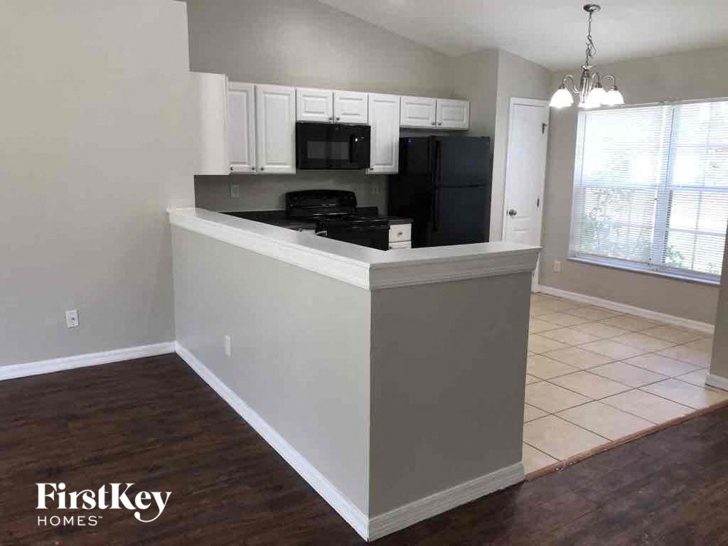 A kitchen with a white island and black appliances.