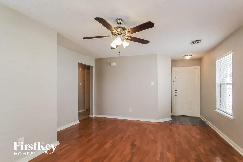 a living room with wood flooring and a ceiling fan