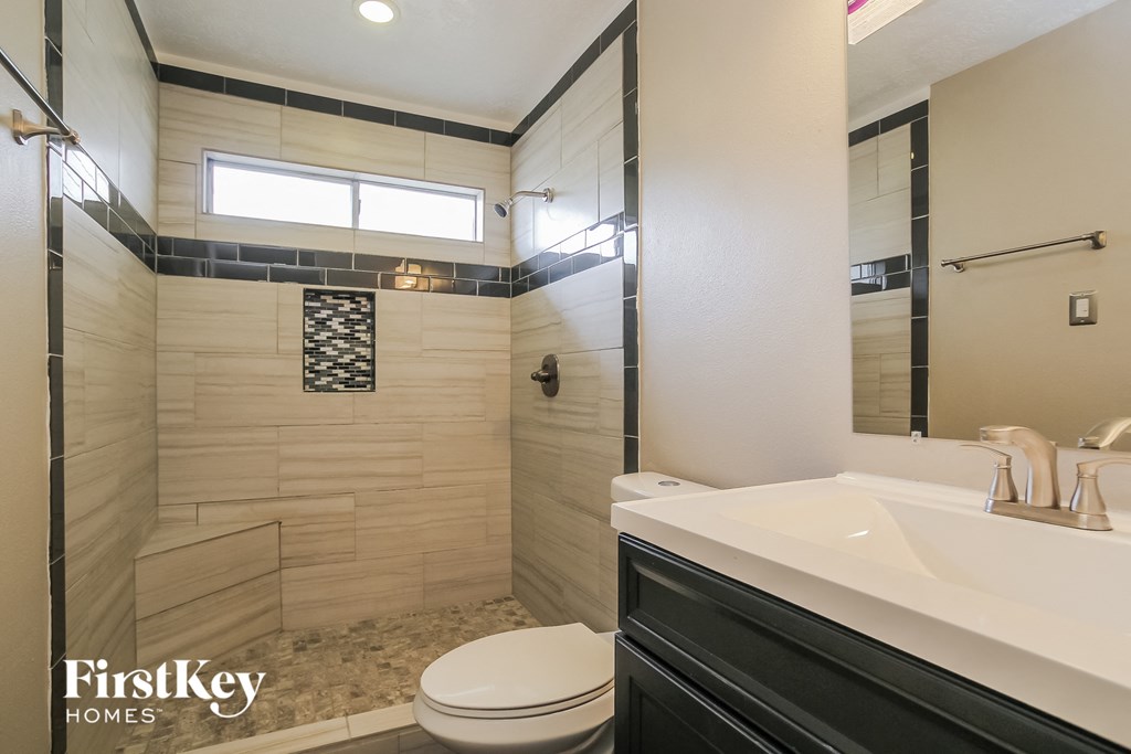 a bathroom with a toilet and a sink and a shower