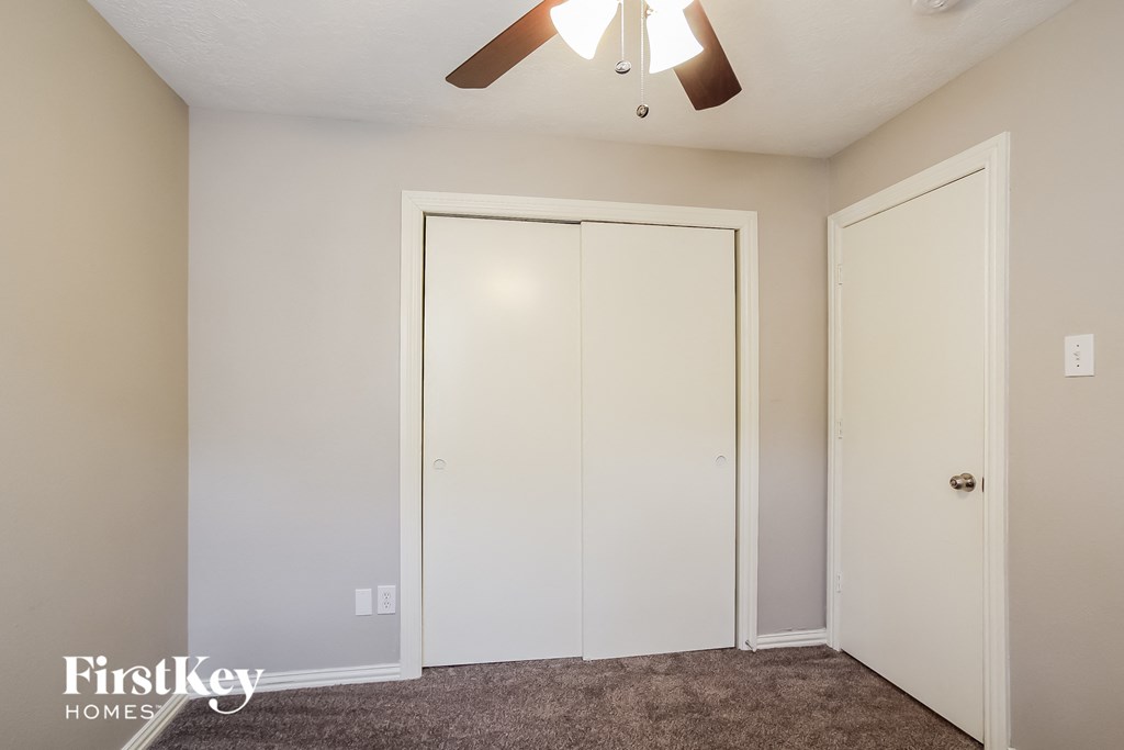 a bedroom with two closets and a ceiling fan