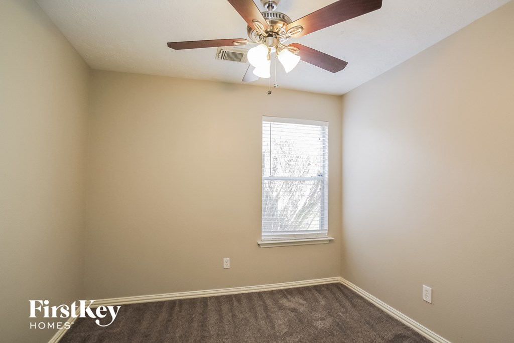 a bedroom with a ceiling fan and a window