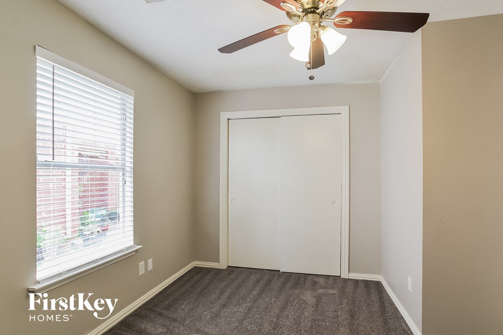 a bedroom with a ceiling fan and a window