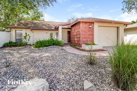 a small house with a gravel driveway and a garage door