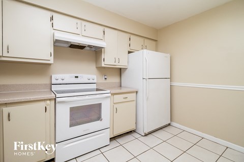 a kitchen with white appliances and a refrigerator