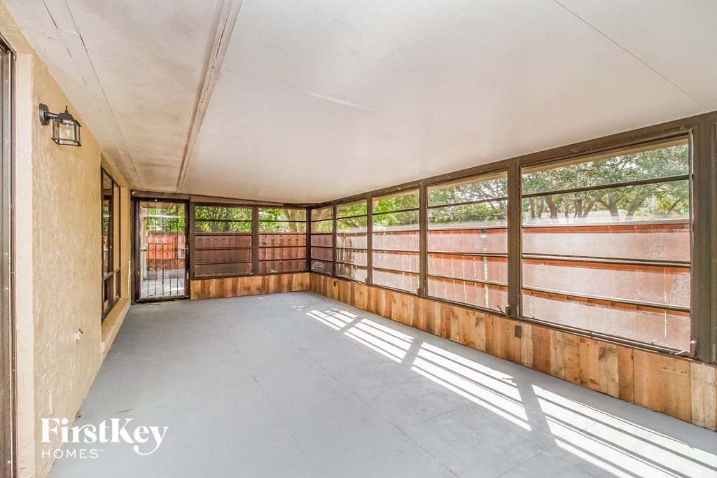 an empty room with wood paneling and windows