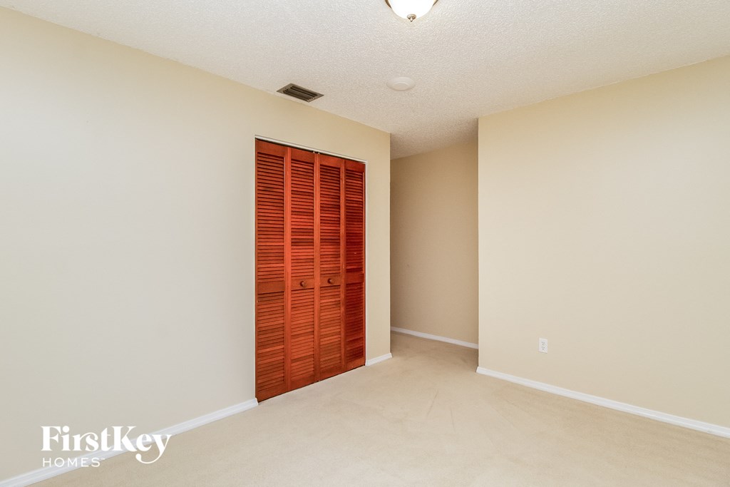 a spacious living room with a door to a closet