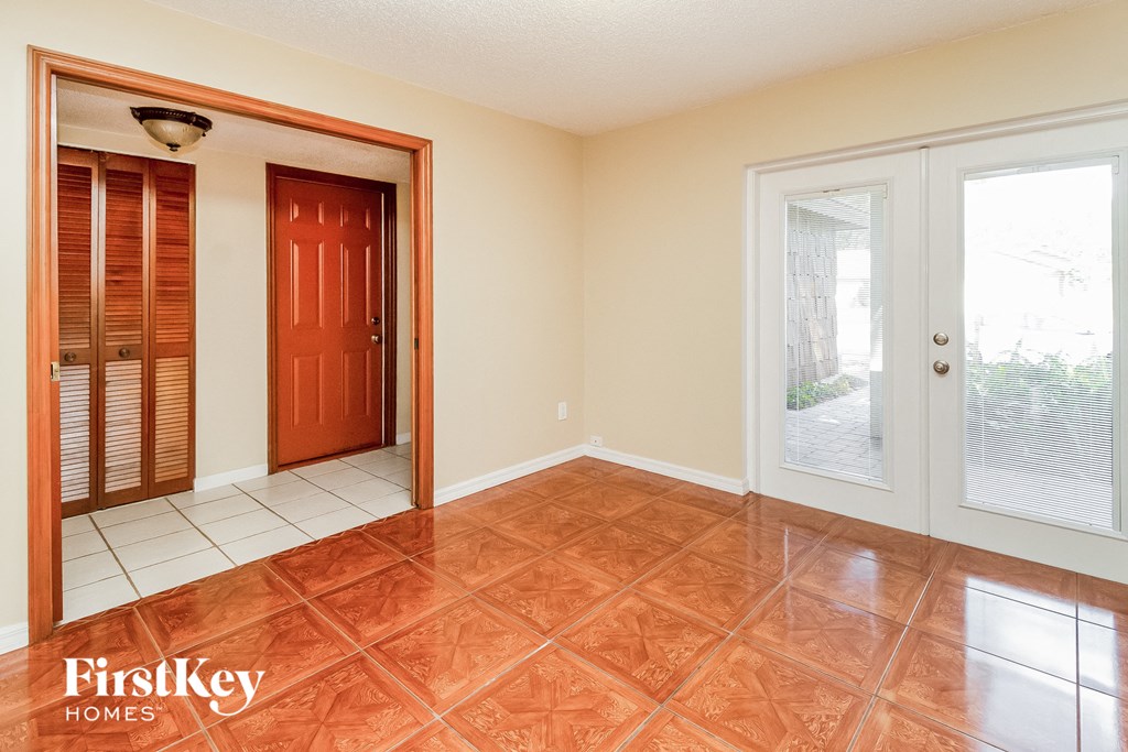 an empty living room with a door to a closet and a window