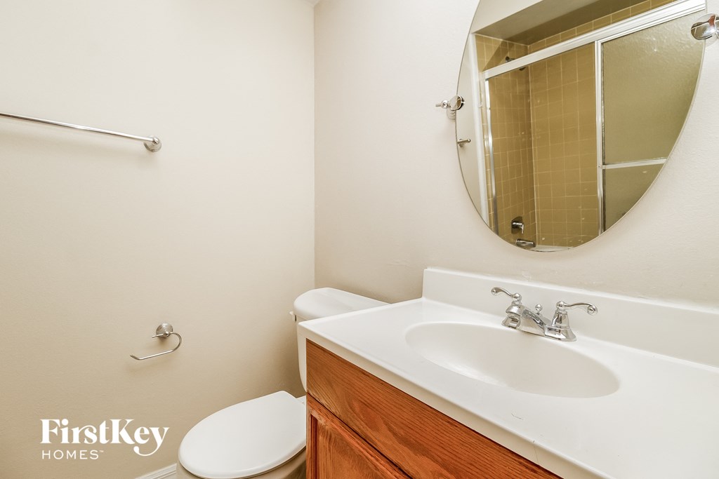 a bathroom with a sink toilet and a mirror