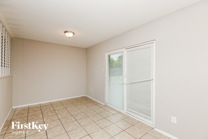 an empty living room with a sliding glass door to a patio